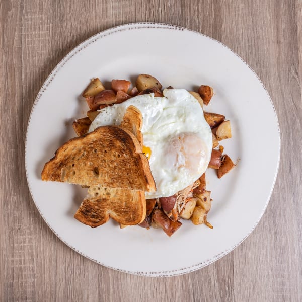 RANGE kitchen & tap's breakfast plate with fried eggs, toast, and roasted potatoes.