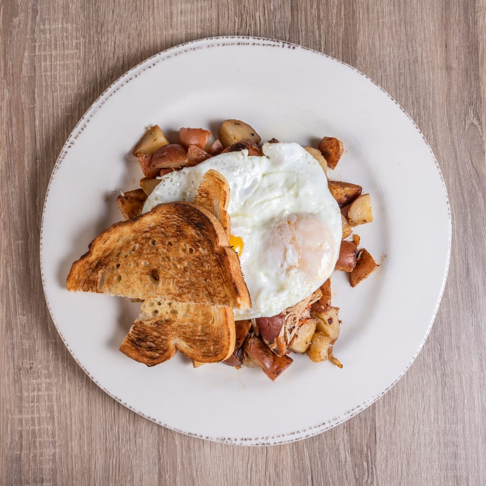 RANGE kitchen & tap's breakfast plate with fried eggs, toast, and roasted potatoes.